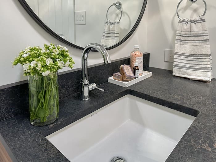 Niagara bathroom renovation with a chrome sink faucet and black quartz countertops