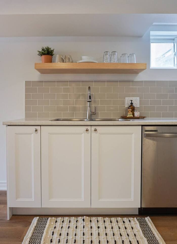 Niagara basement kitchen renovation with white cabinet, sink, and open wooden shelf
