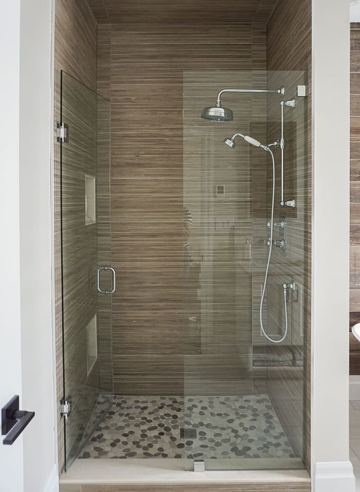 Niagara bathroom glass shower with brown wall tile and stone flooring