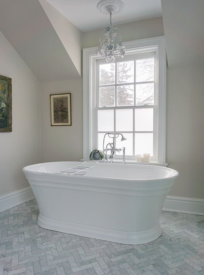 Niagara bathroom renovation white bathtub and herringbone marble tile floors