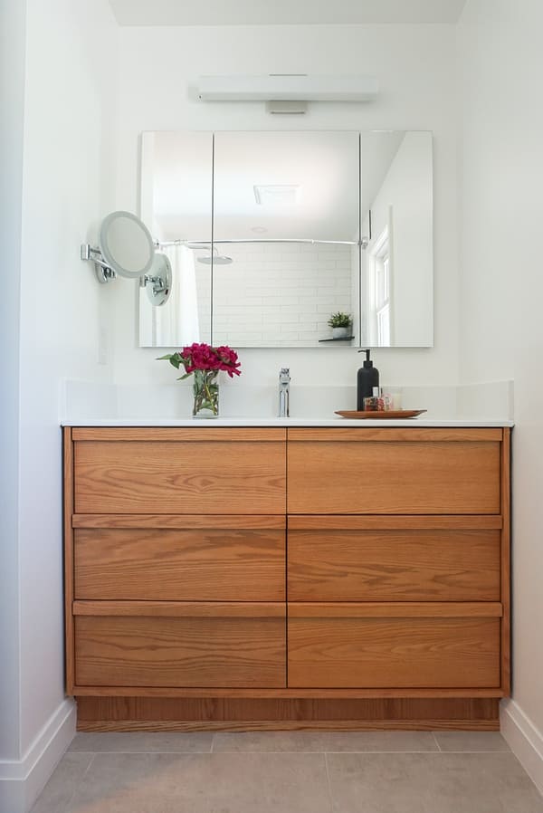 Niagara bathroom renovation with modern wooden vanity, white counters, and medicine cabinet