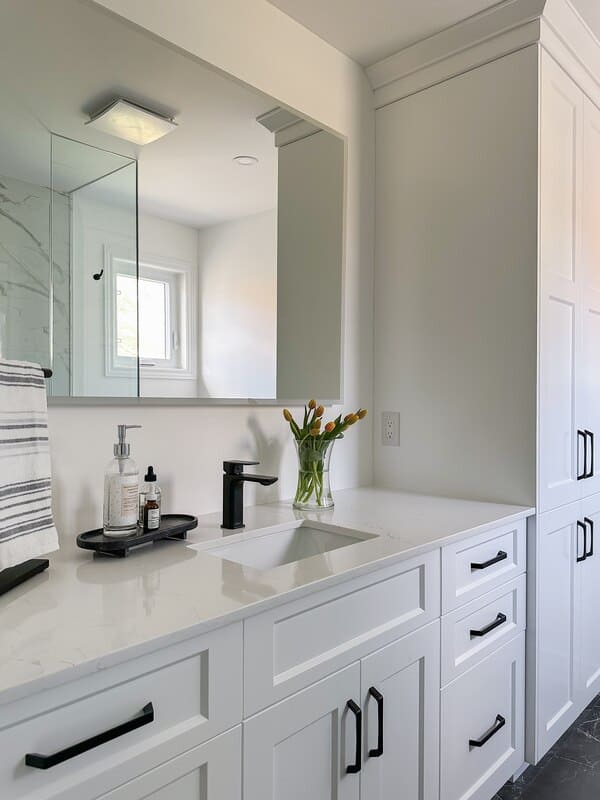fonthill bathroom renovation with white custom vanity, white quartz counter, black hardware, and linen tower